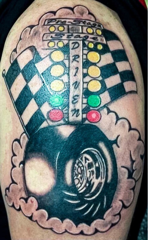 Drag racing tattoo with a starting tree, checkered flags and a tire
