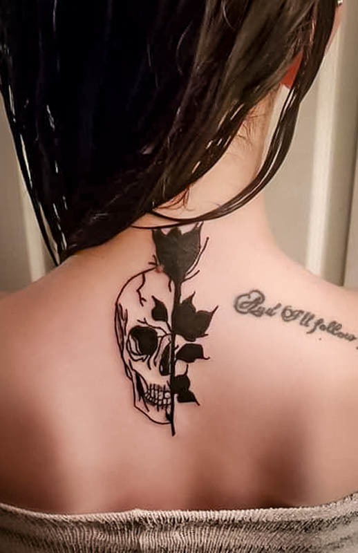 Half skull and rose tattoo on the upper back