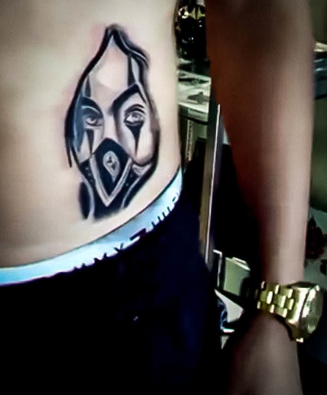 Black and grey masked face tattoo on the side