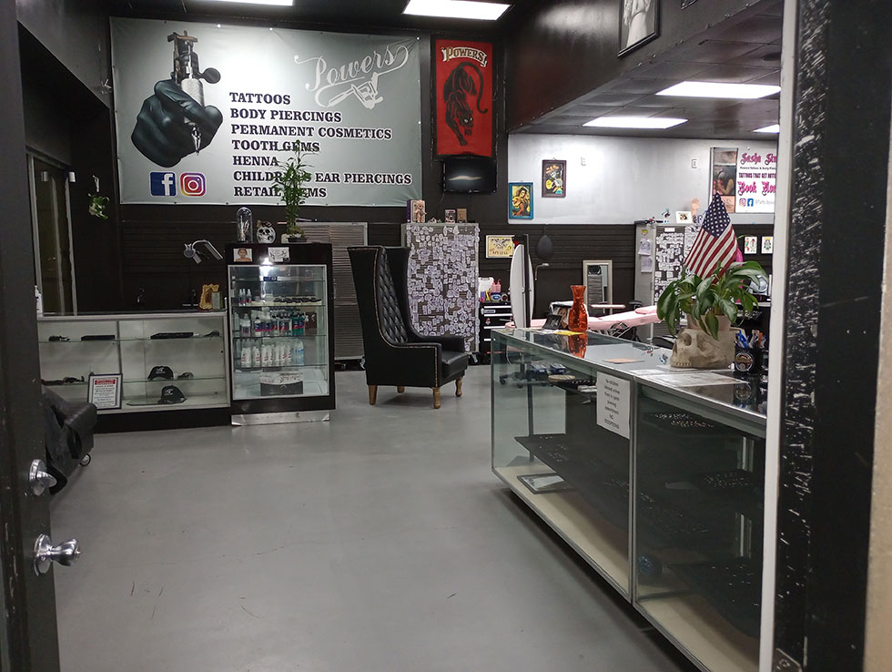 Inside the Powers studio with display cases and the services banner