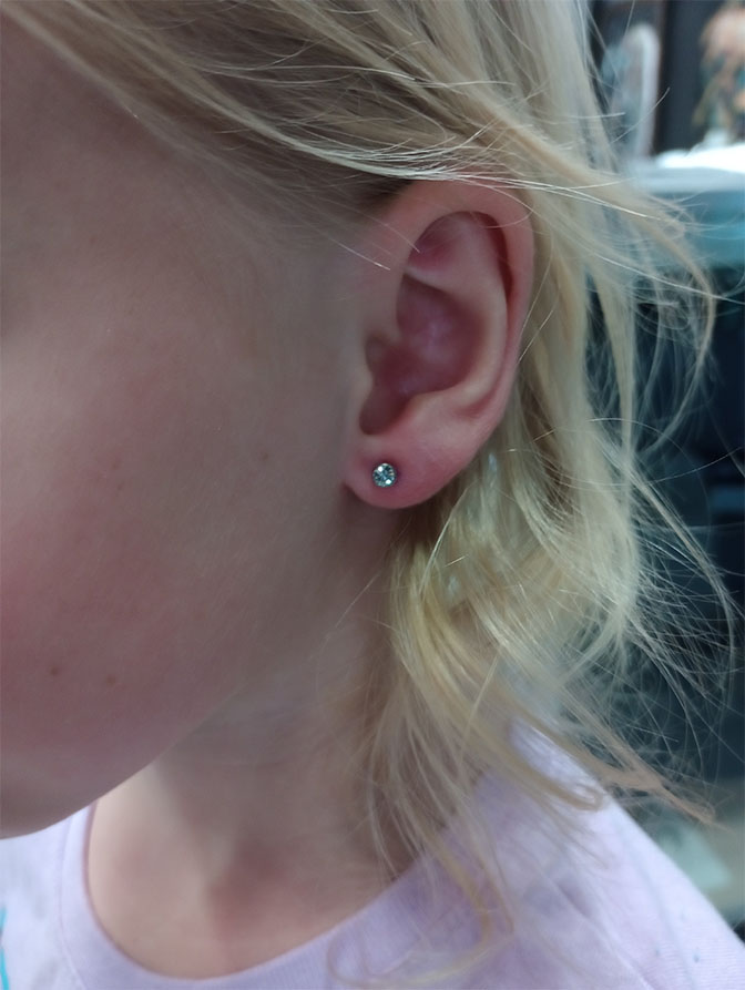 Child's ear piercing with a crystal stud