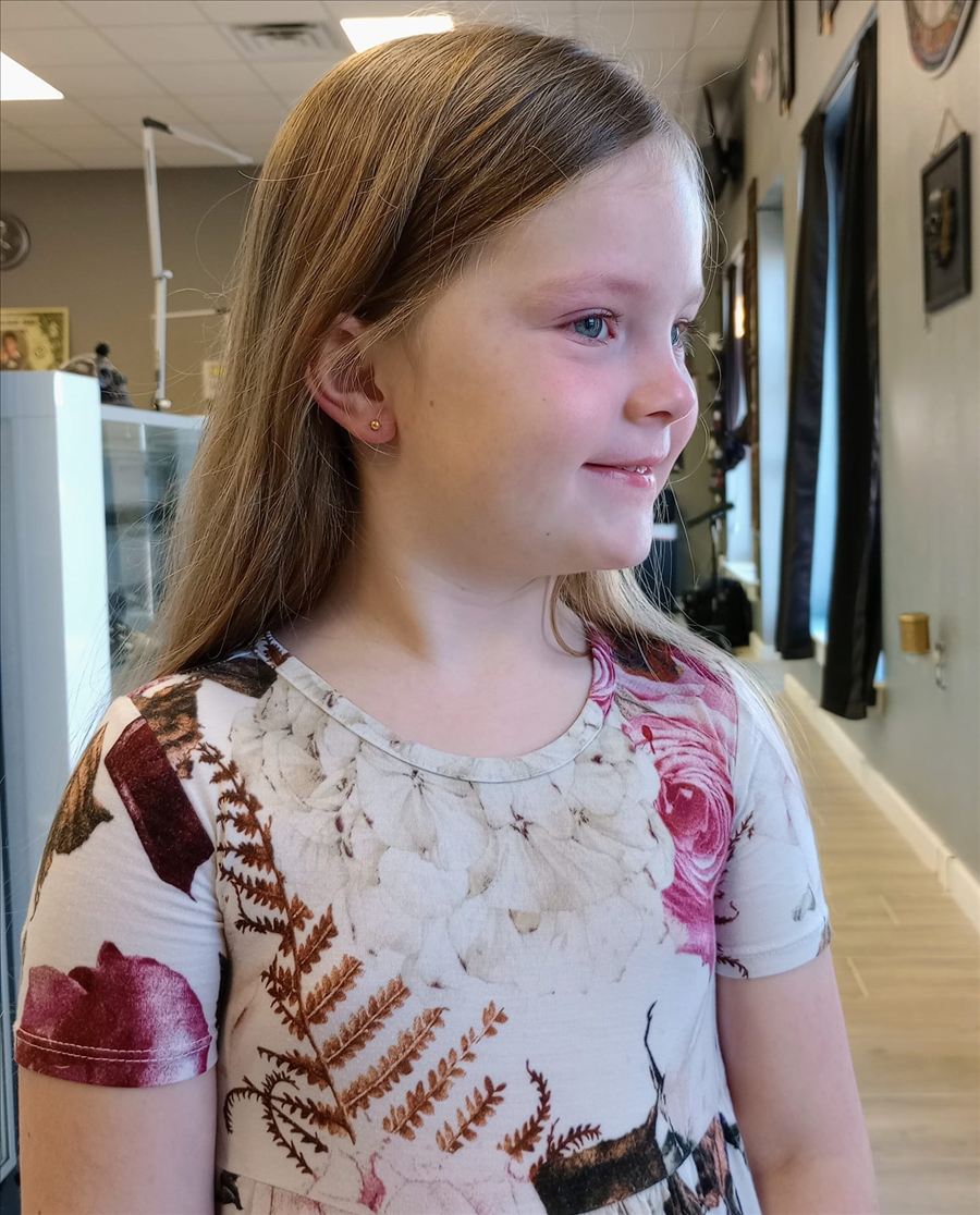 Smiling girl showing her newly pierced ear